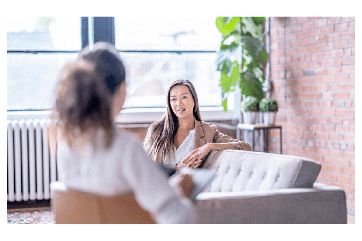 Two women sitting together talking in therapy session