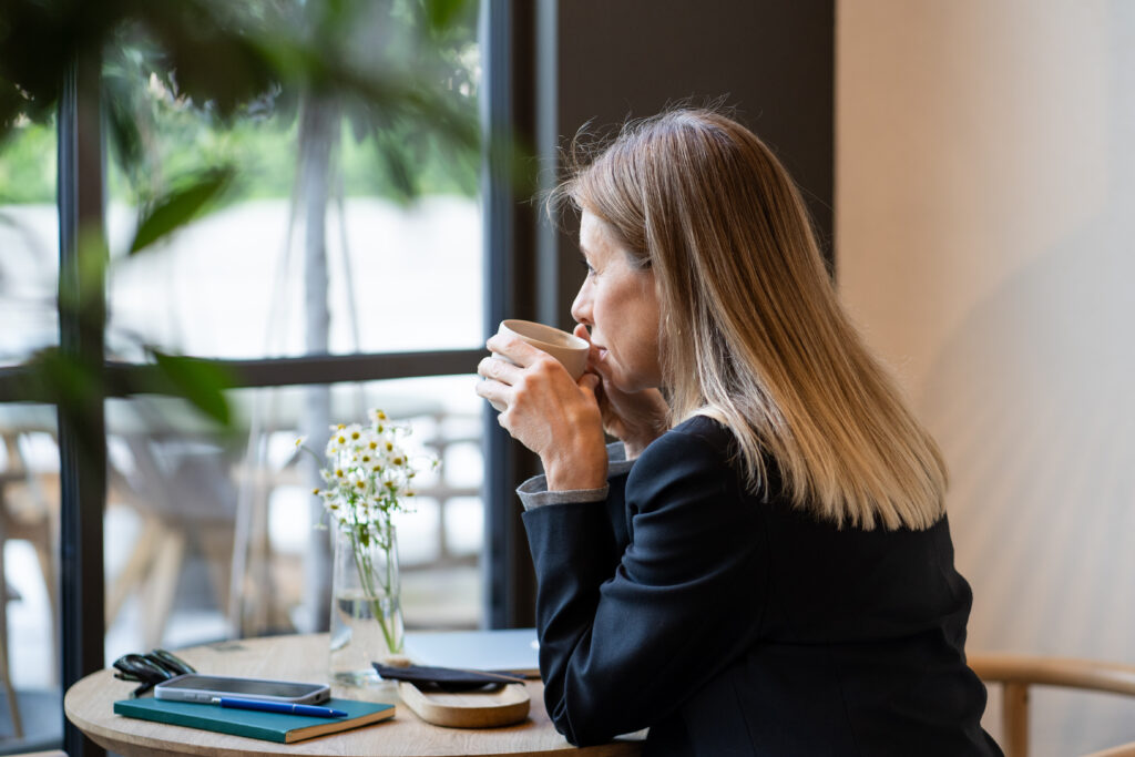A woman staring off into the window trying to manage her high-functioning anxiety.