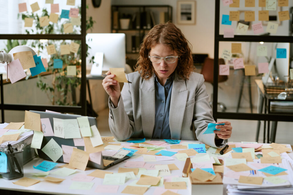 High achieving woman at work with a messy desk due to overwhelm and high-functioning anxiety.