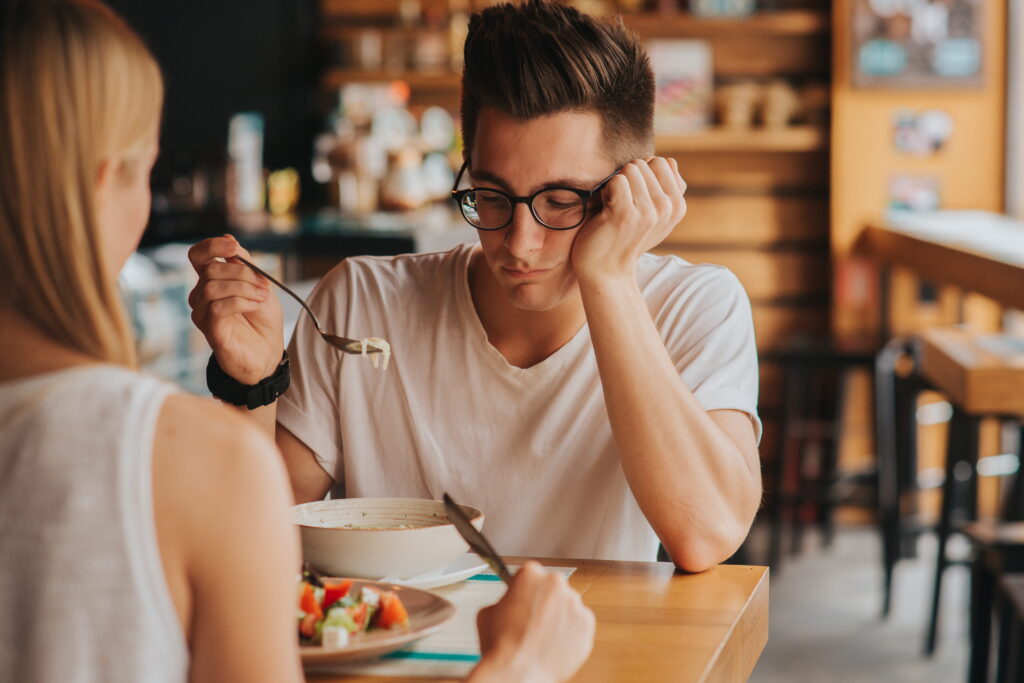 Young man showing signs of distress around food, illustrating the difference between eating disorder vs disordered eating