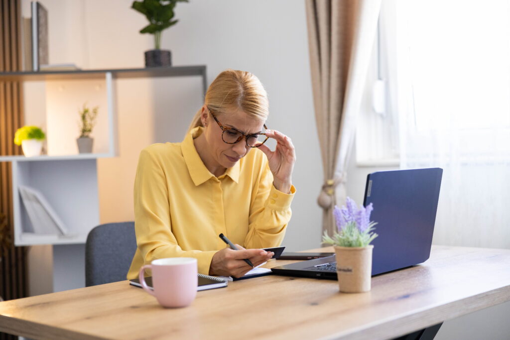 A women sitting at a desk dealing with perfectionism and people-pleasing.